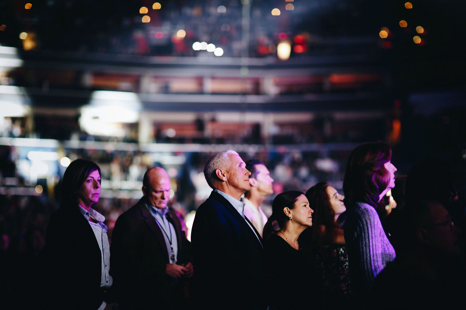 Crowd faces lit from the stage